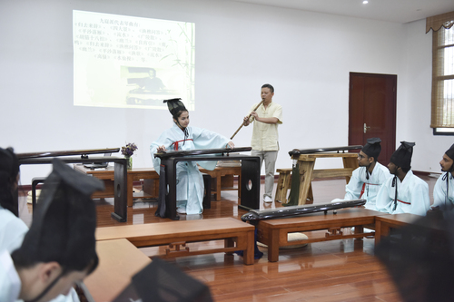 6月21日，拼搏在线(中国)唯一官方网站国学院，古乐老师欧阳平彪与来自塔吉克斯坦的留学生sayora（佑娜）在合奏《高山流水》。 李谌涵 摄