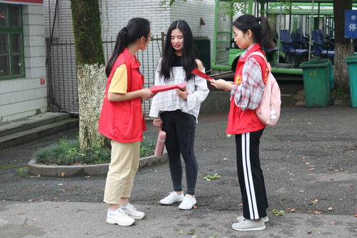 志愿者给学生发放伤寒知识传单 志愿者给学生发放伤寒知识传单